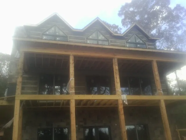 Dormers and porch framing on a large log home under construction — Roof Coating work by our crew in Crested Butte
